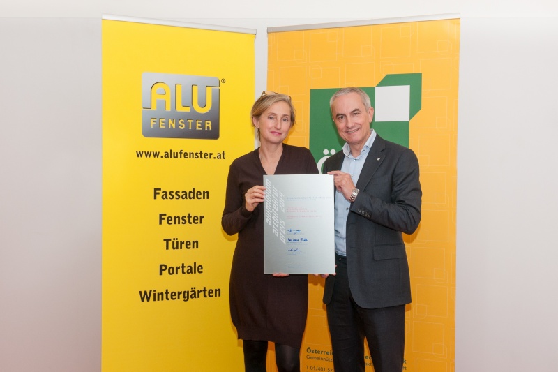 Architektin Elke Delugan Meissl und ÖSW-Vorstand Michael Pech mit der Auszeichnungstafel aus Aluminium